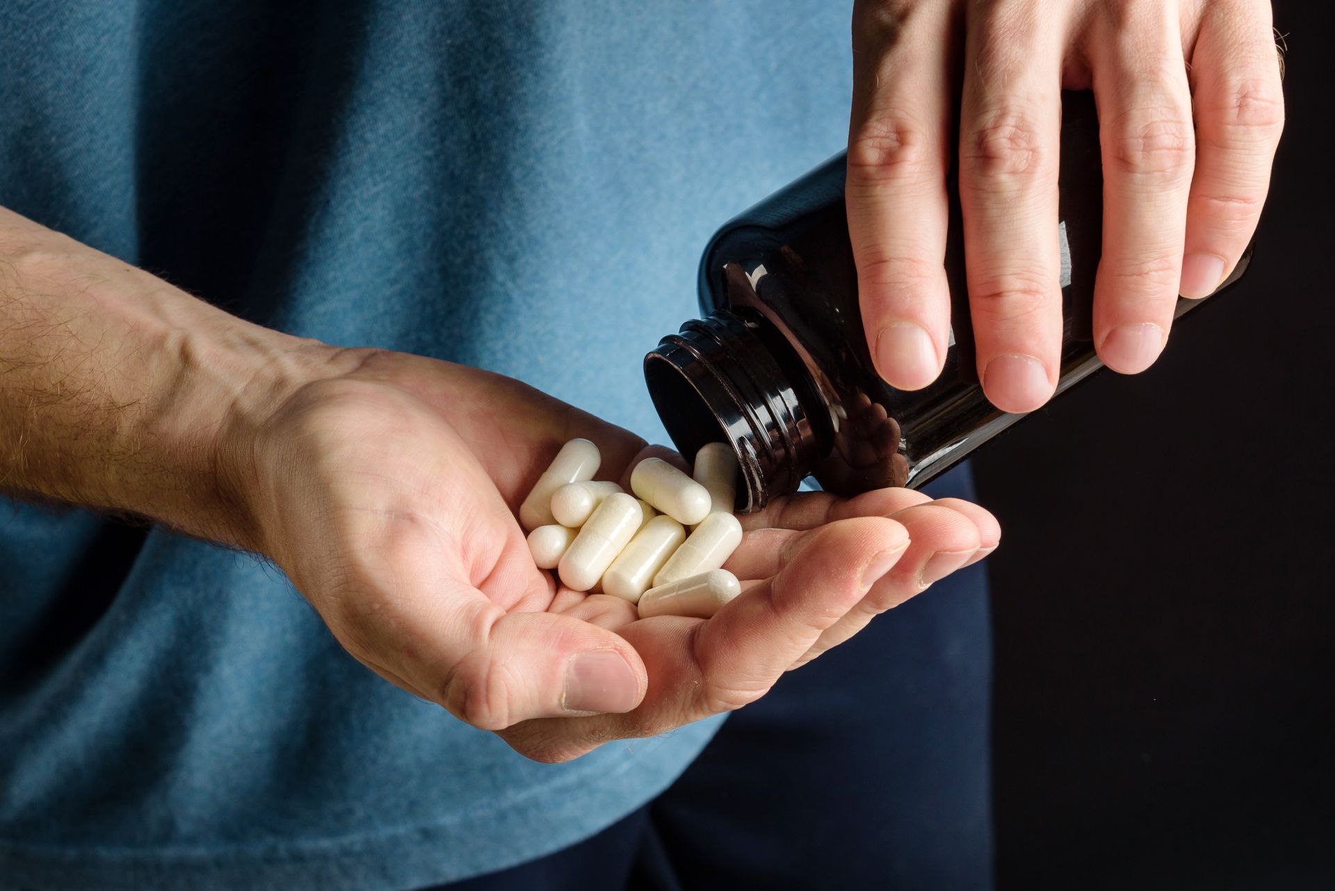 Kanna y energía: ¿qué relación guardan? Mężczyzna wysypuje kapsułki na dłoń